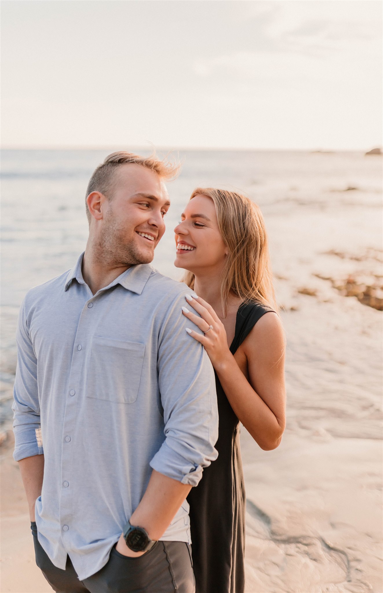 couple looking at each other and smiling at the beach