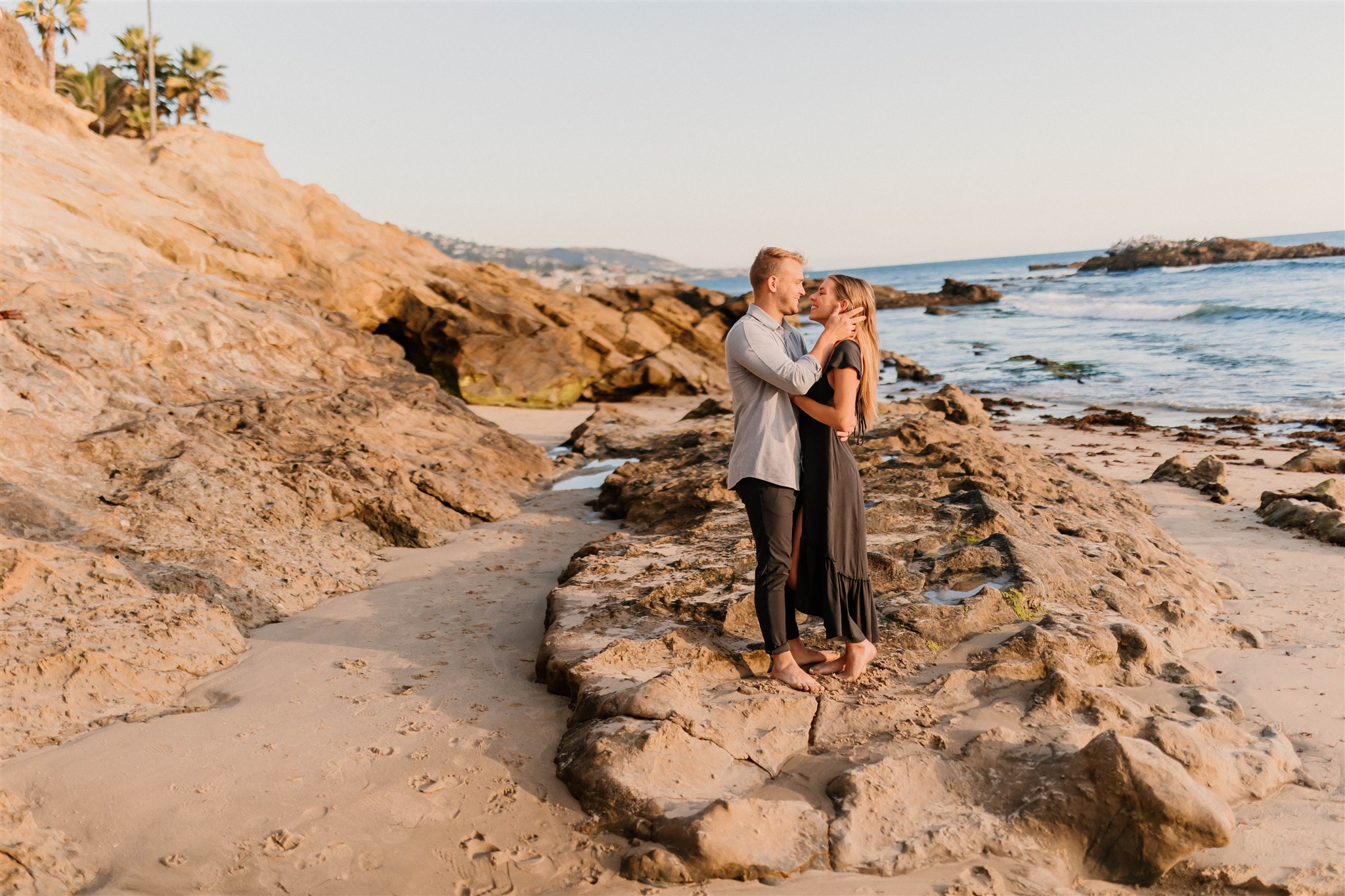 couple posing on the rocks on the beach