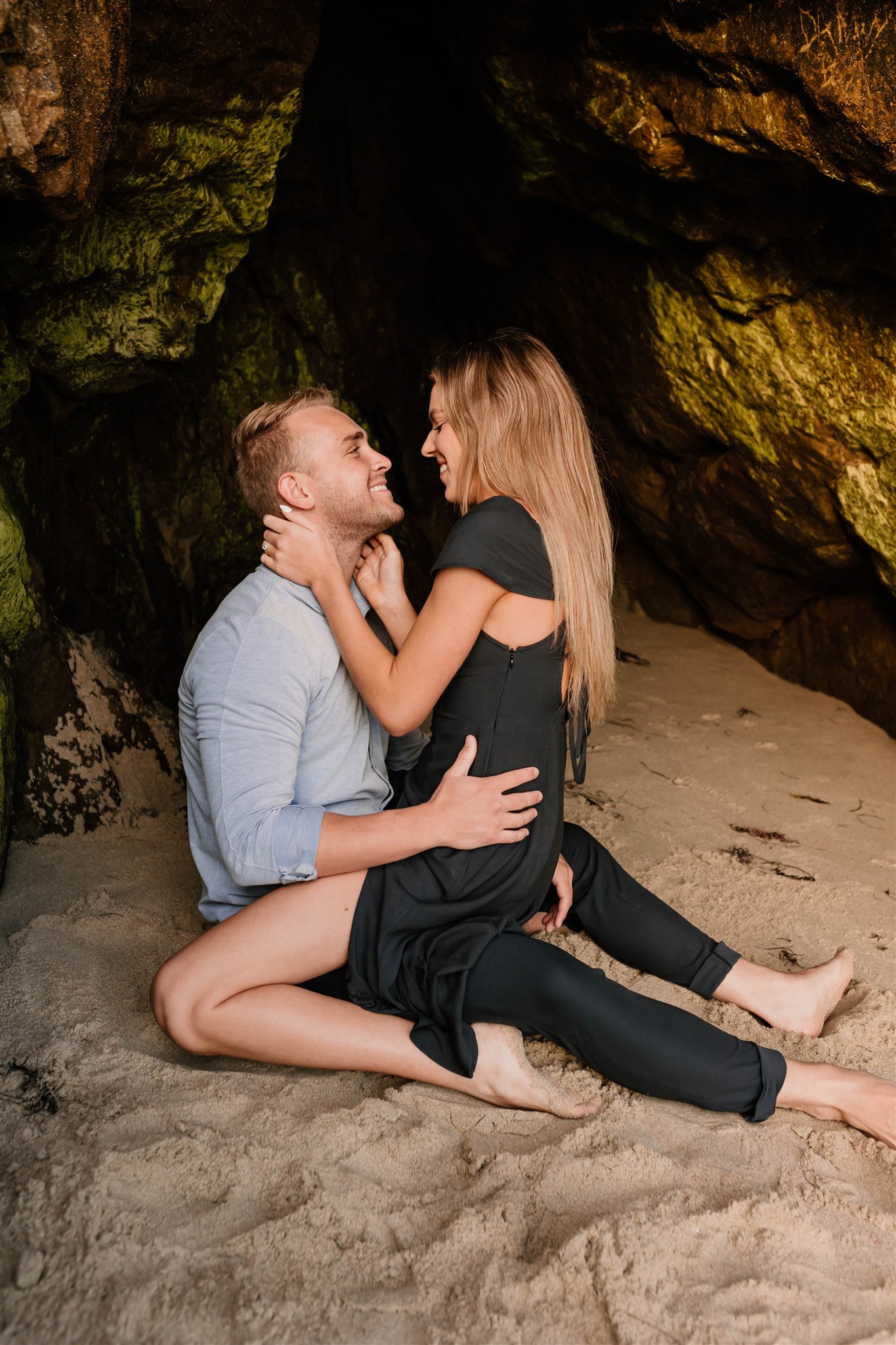 couple sitting in a cave on the beach
