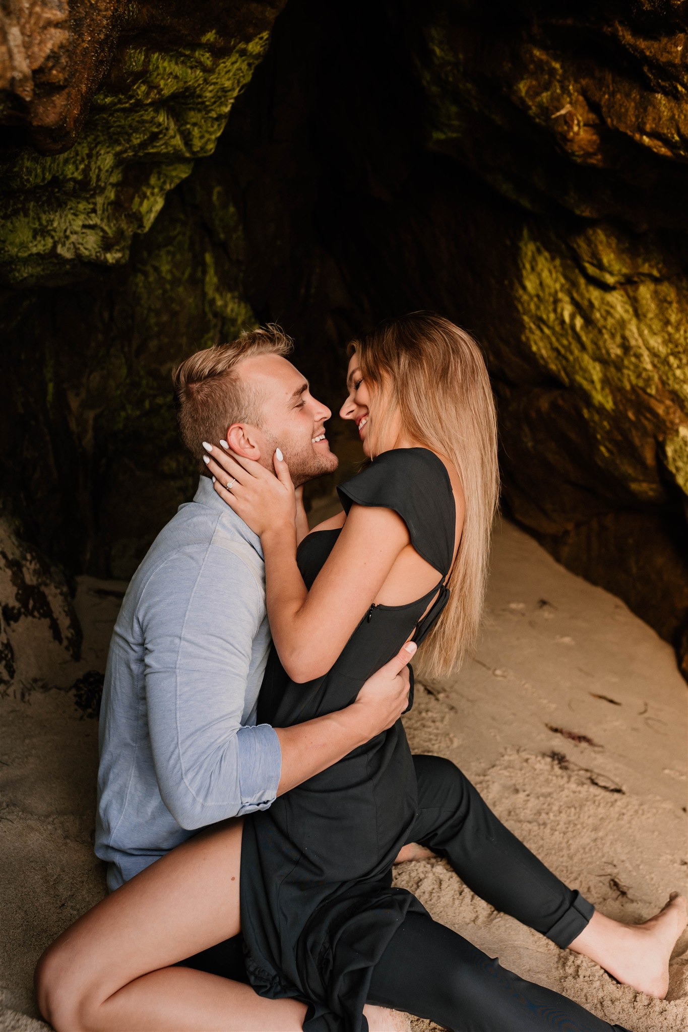 couple posing in a cave on the beach