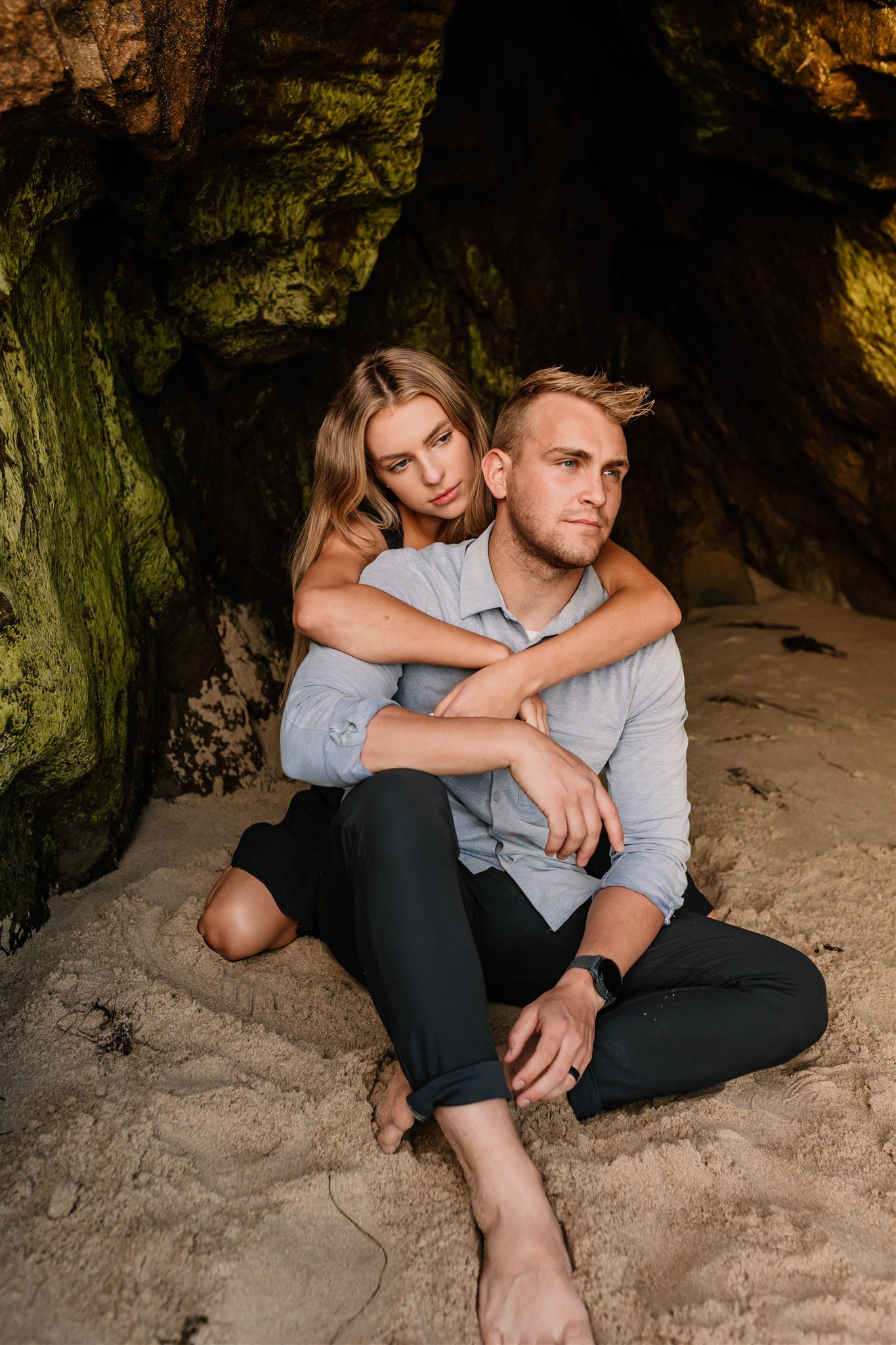couple posing in a cave on the beach