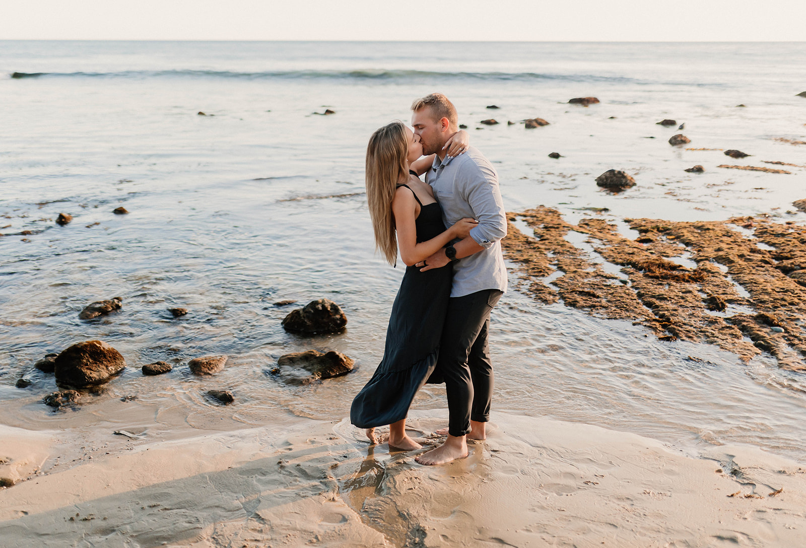 couple posing and kissing on laguna beach