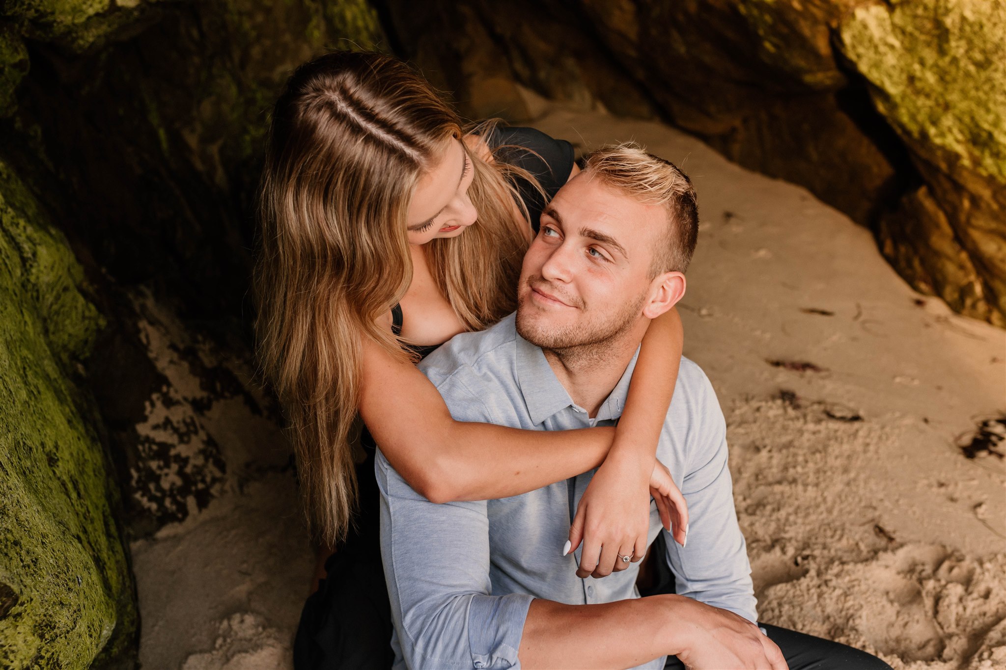couple looking at eachother in a cave on a beach