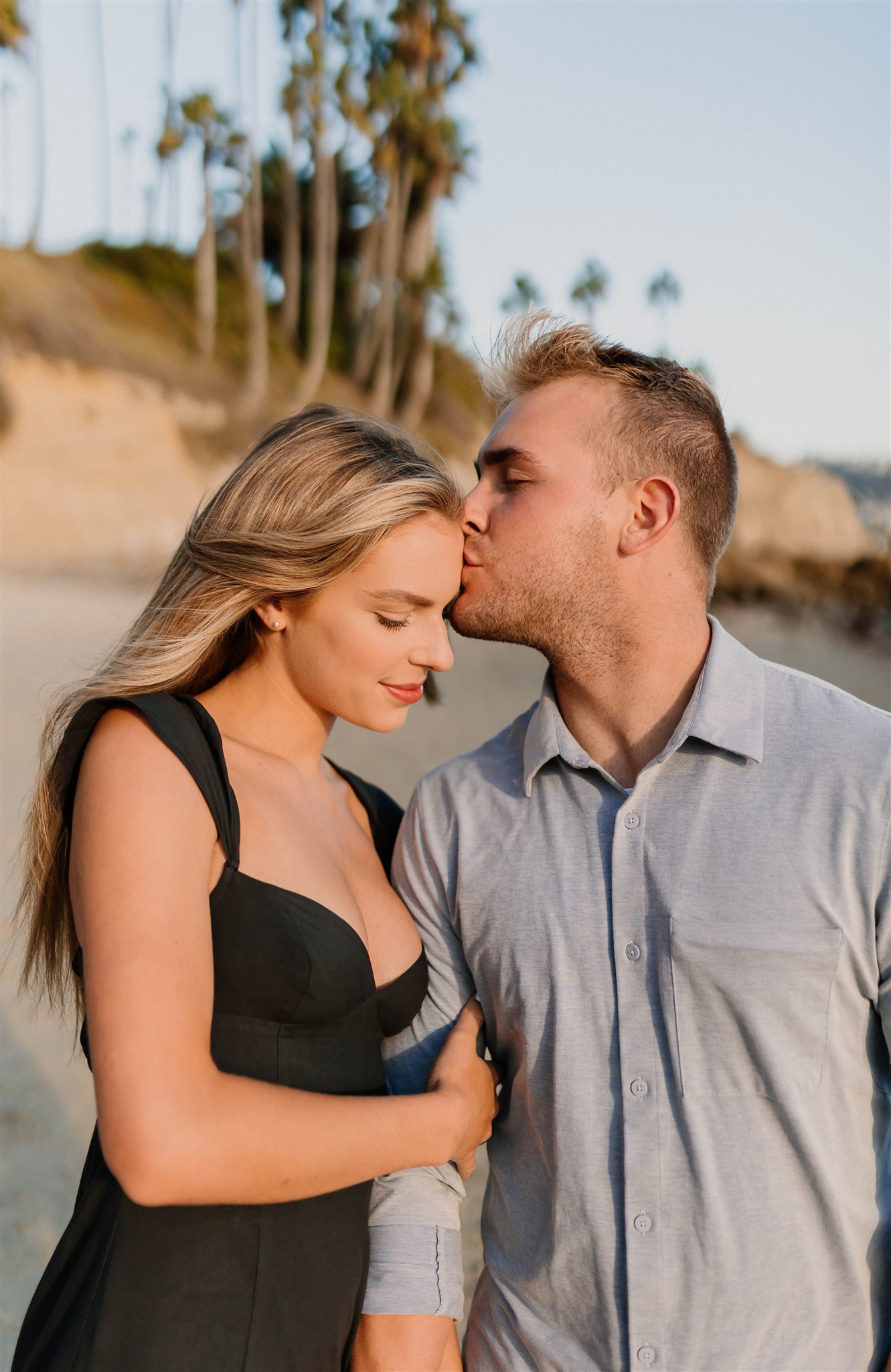 guy kissing girl on the head on a beach Fun and Playful Laguna Beach Couples Photos