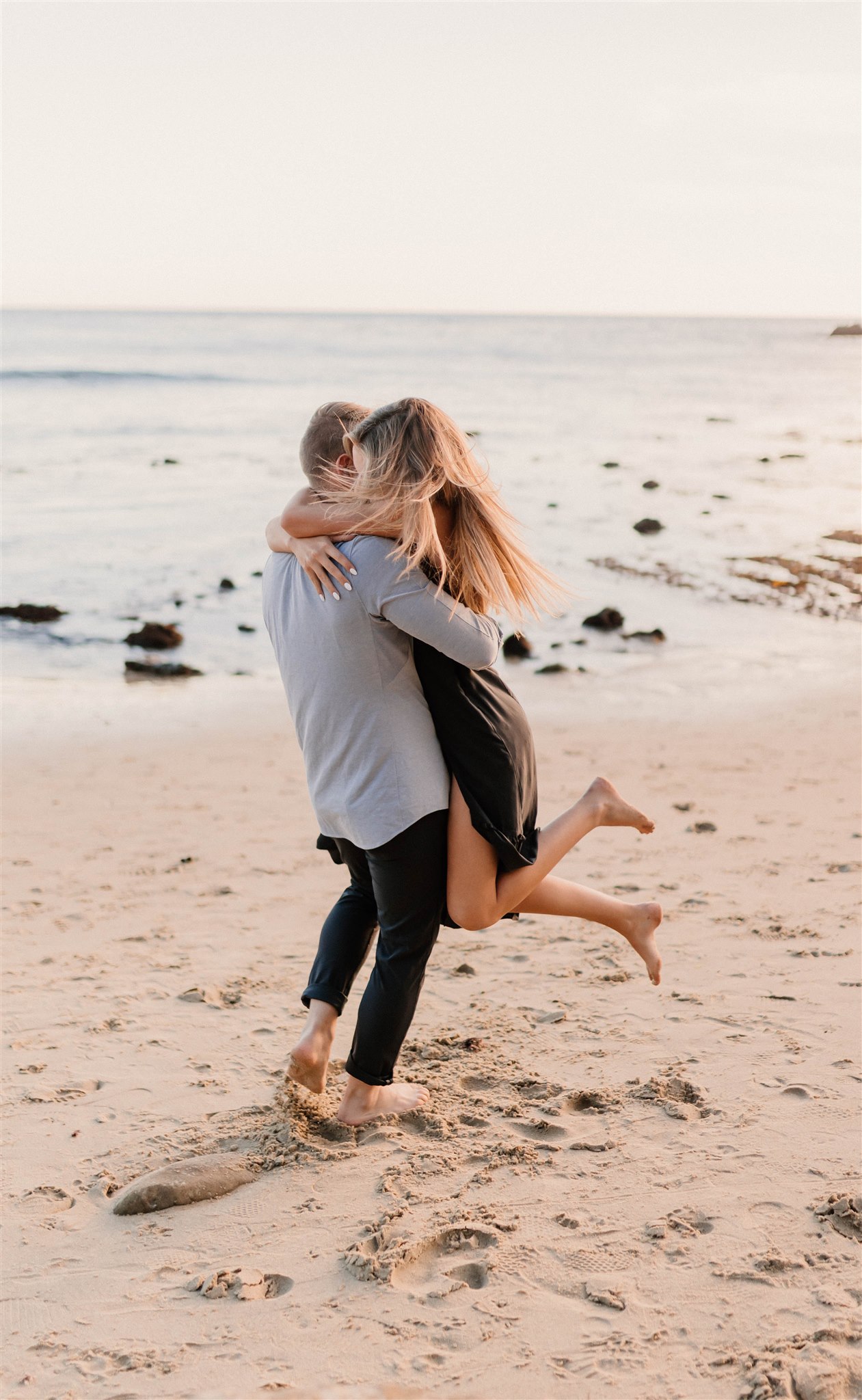 couple twirling on a beach Fun and Playful Laguna Beach Couples Photos
