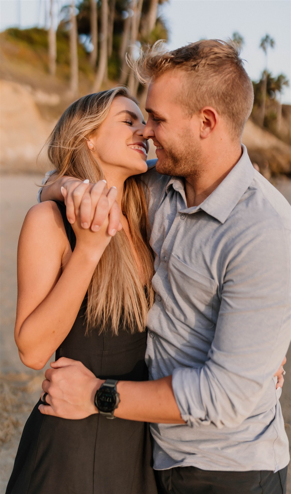 couple kissing and smiling at a beach Fun and Playful Laguna Beach Couples Photos