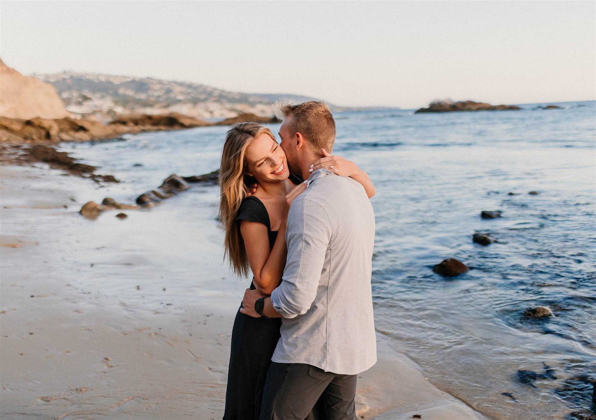 couple laughing and kissing on a beach Fun and Playful Laguna Beach Couples Photos