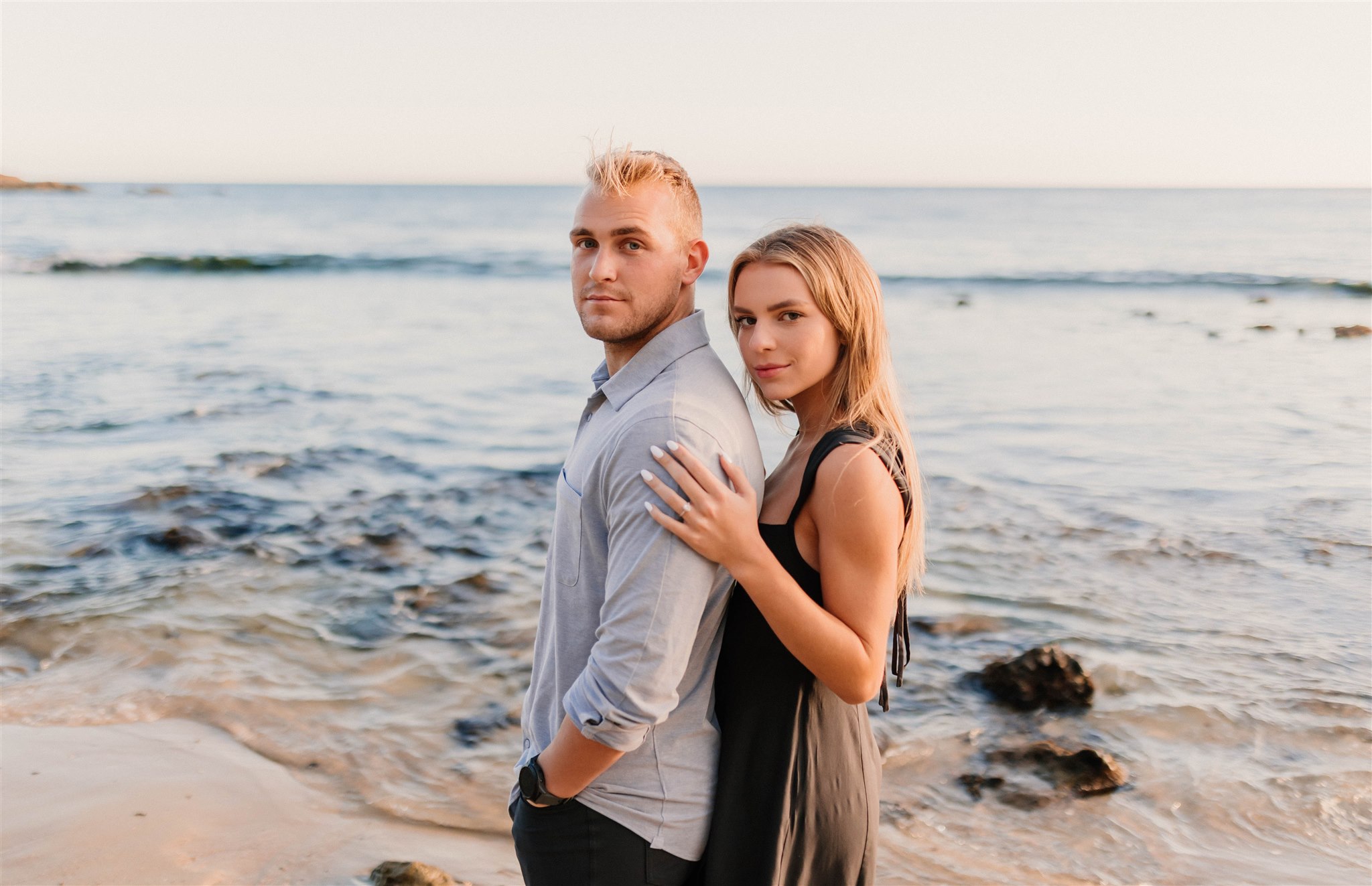 couple posing in front of the ocean
