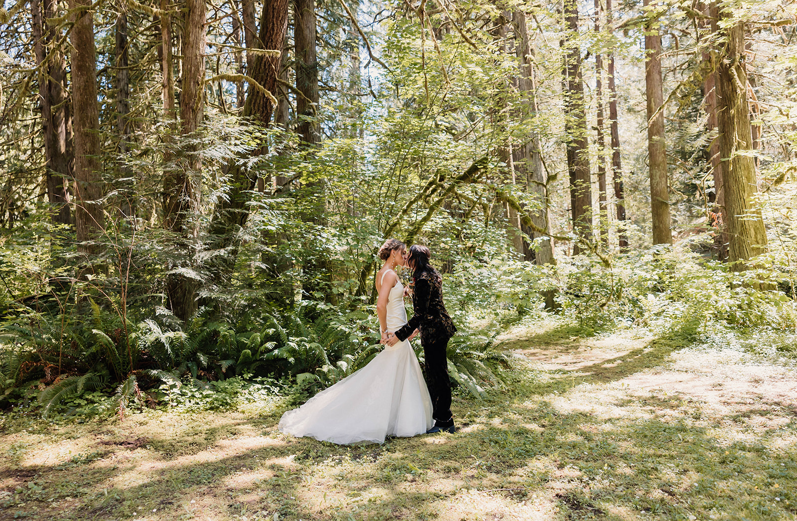 married couple kissing in a forest