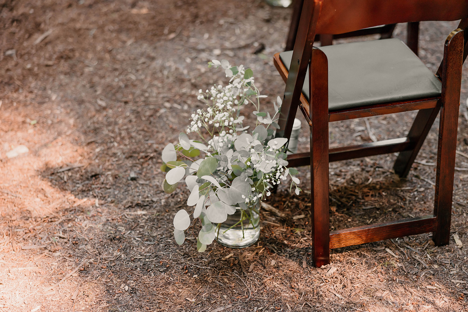 wedding flowers next to a chair on the aisle Camp Colton - A Mystical Oregon Wedding Venue