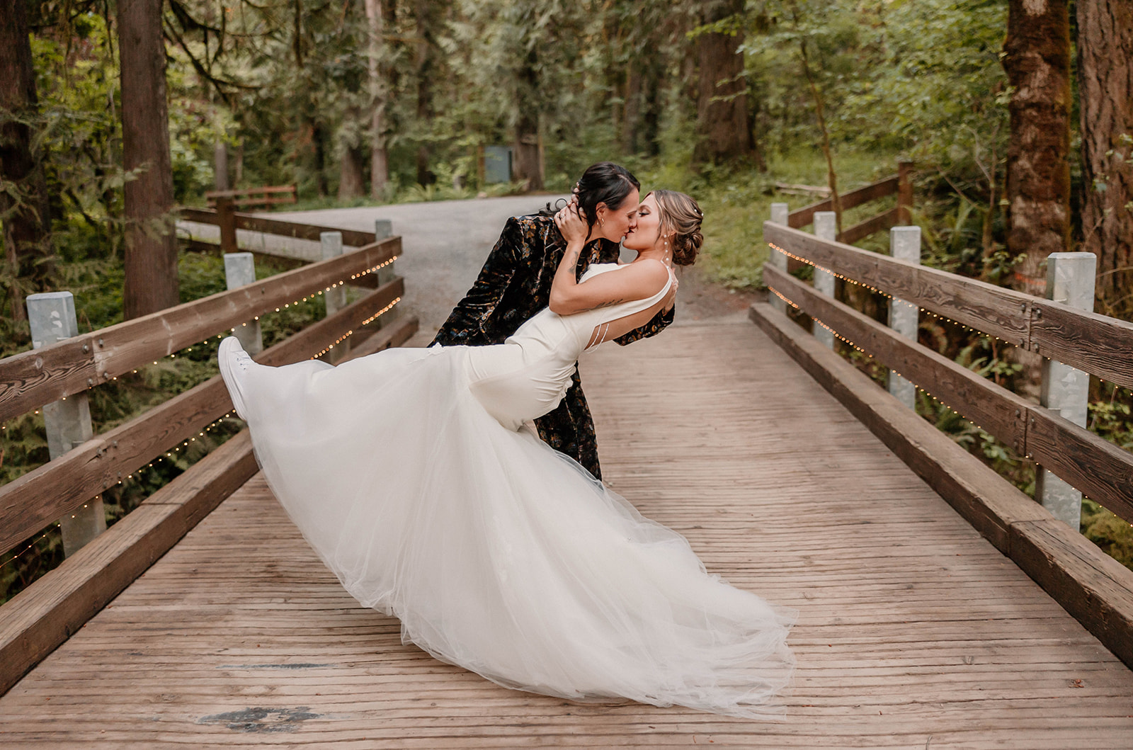Married couple kissing on a bridge