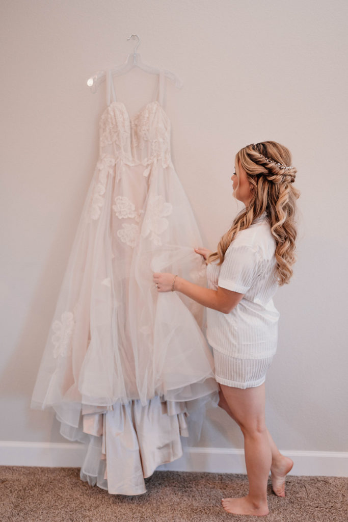 Bride admiring her wedding dress