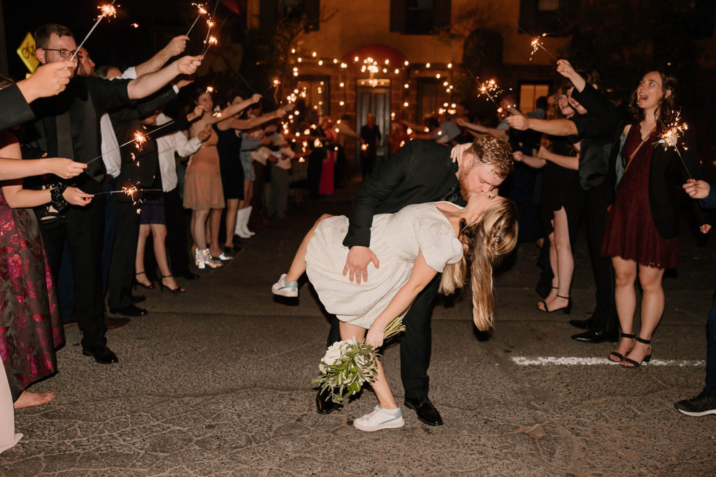 bride and groom kissing at wedding sparkler exit