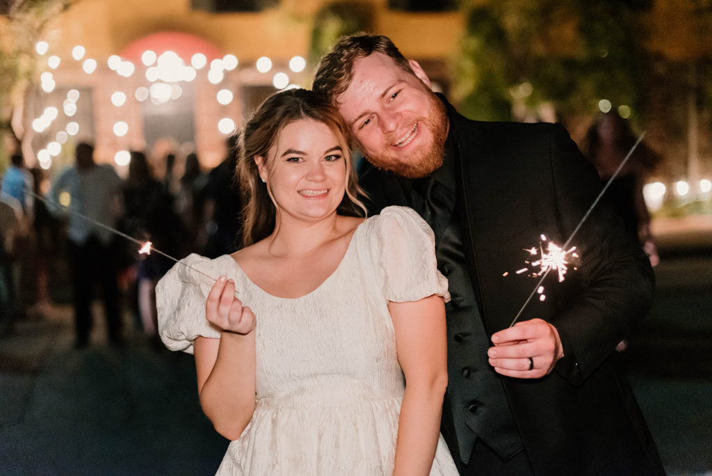 bride and groom smiling with sparklers
