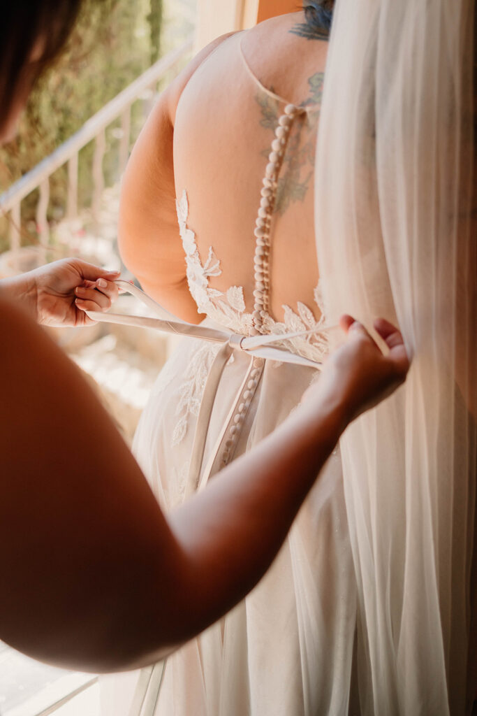 Bride getting dress tied up