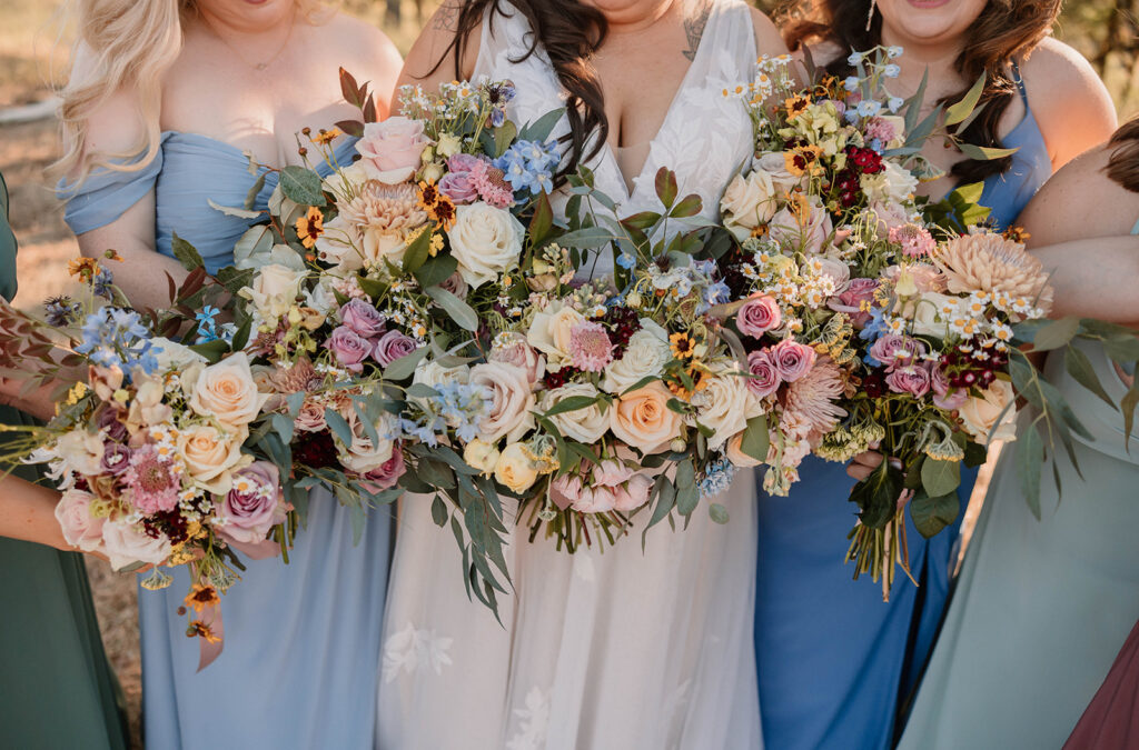 Bride and bridesmaids holding spring wedding flowers