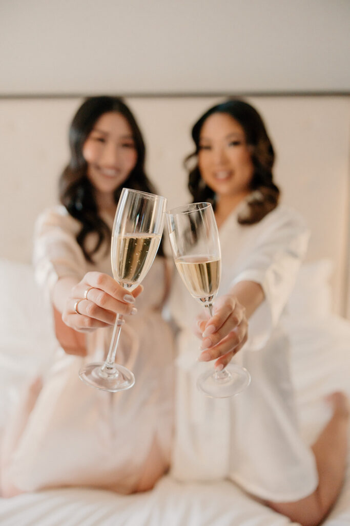 Bride and bridesmai toasting with champagne before ceremony