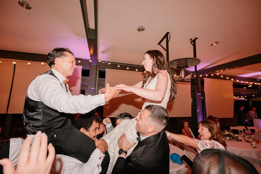 Bride and groom being lifted in the air during wedding reception