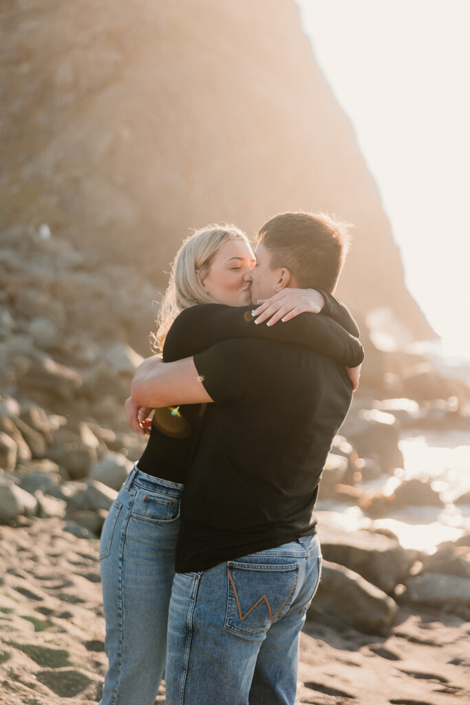 a couple posing for their proposal photos on the beach
