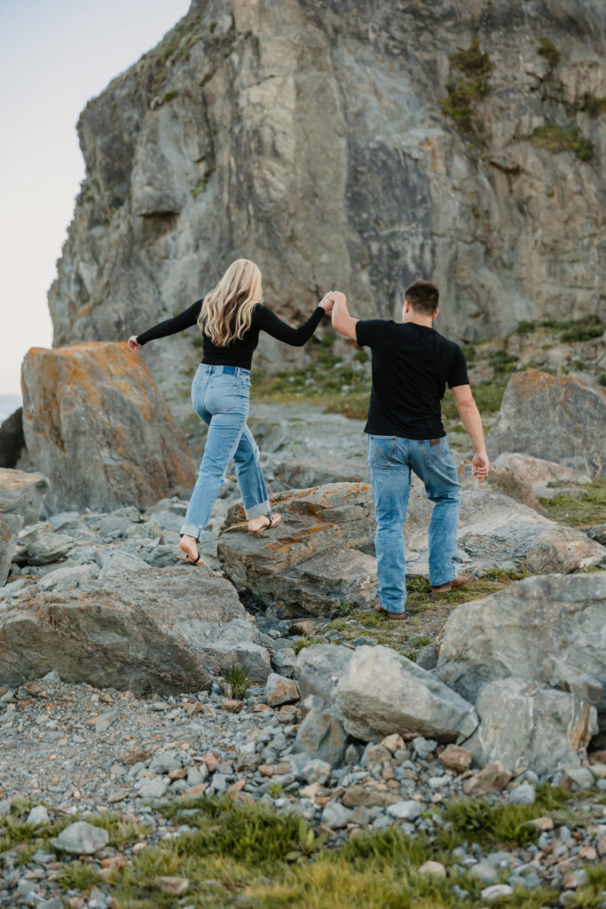 a couple posing for their proposal photos on the beach
