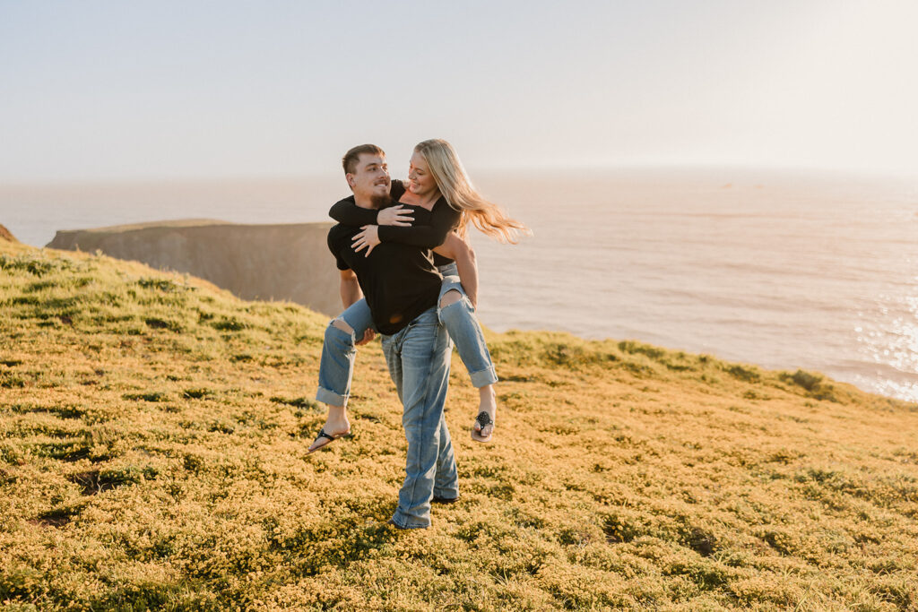 a couple posing for their proposal photos on the beach
