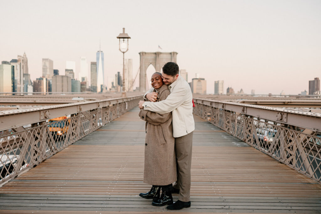 couple taking photos on the brooklyn bridge
