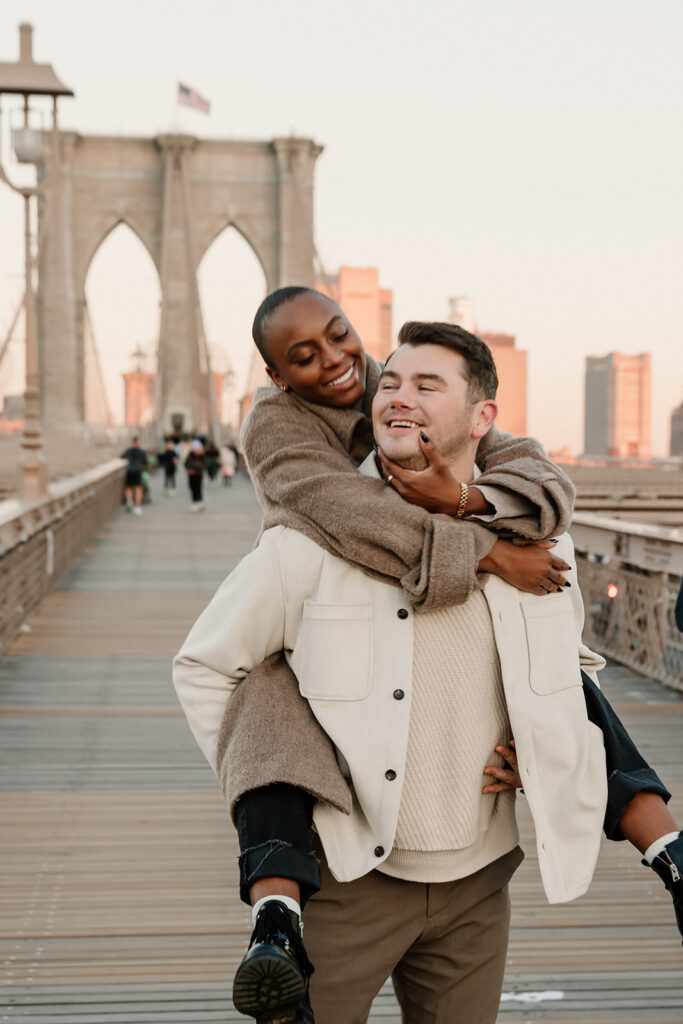 couple taking photos on the brooklyn bridge