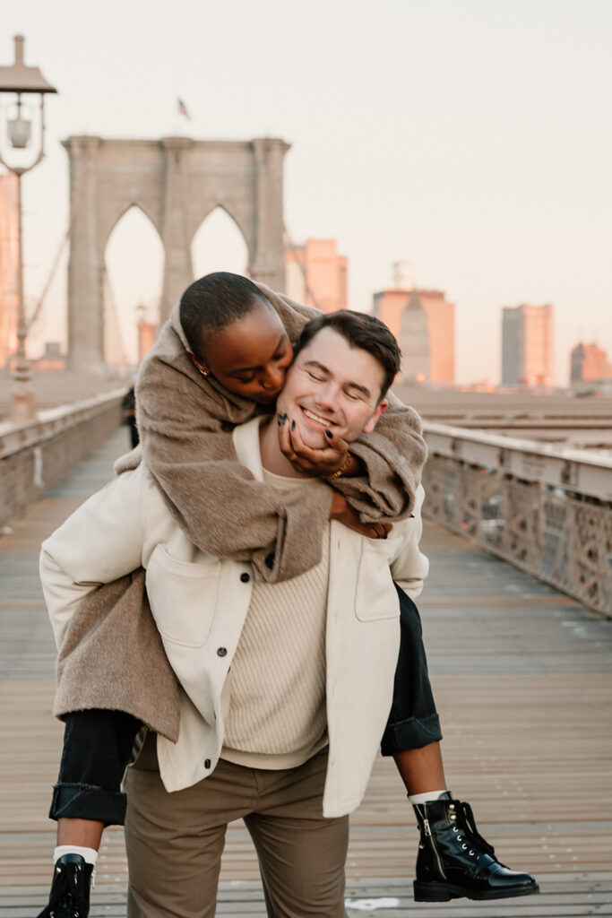 couple taking photos on the brooklyn bridge
