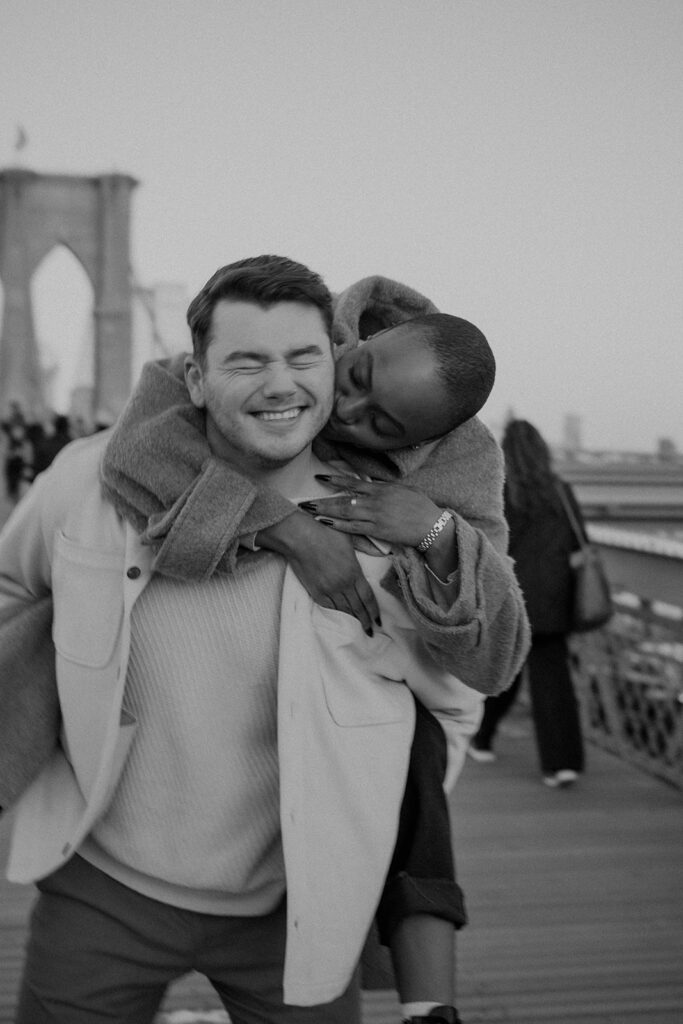 couple taking photos on the brooklyn bridge
