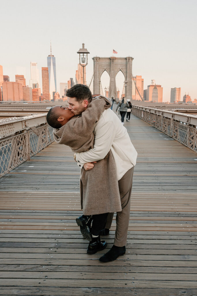 couple taking photos on the brooklyn bridge
