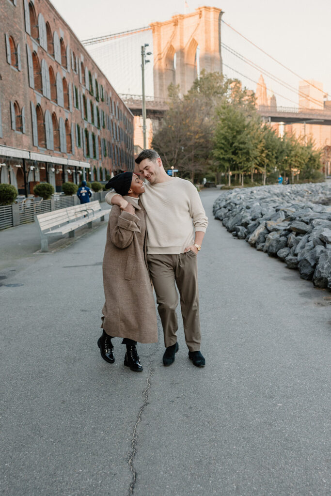 couple taking photos on the brooklyn bridge
