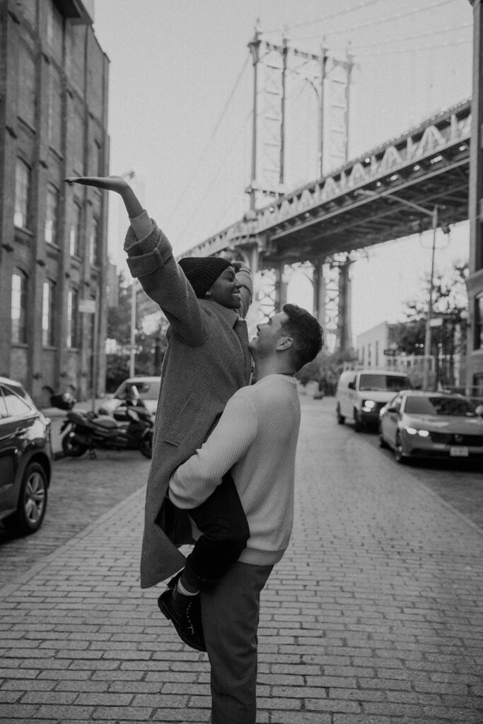 couple taking photos on the brooklyn bridge
