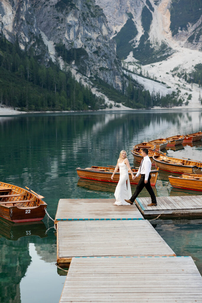 A couple standing together during their destination elopement photoshoot at Lago di Braies in the Dolomites, Italy.
