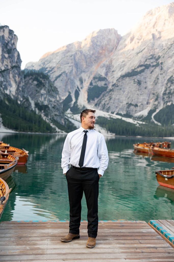 A pair enjoying their elopement photoshoot in the stunning setting of Lago di Braies, surrounded by the Dolomites in Italy.
