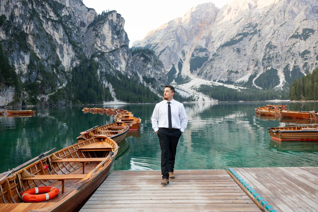 A pair enjoying their elopement photoshoot in the stunning setting of Lago di Braies, surrounded by the Dolomites in Italy.