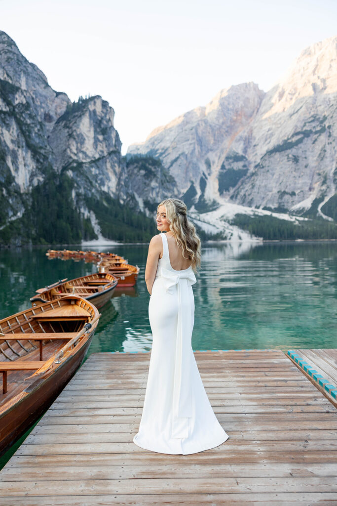 Two people posing by the picturesque Lago di Braies in the Dolomites for their destination elopement photos.
