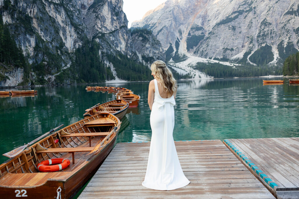 A pair enjoying their elopement photoshoot in the stunning setting of Lago di Braies, surrounded by the Dolomites in Italy.