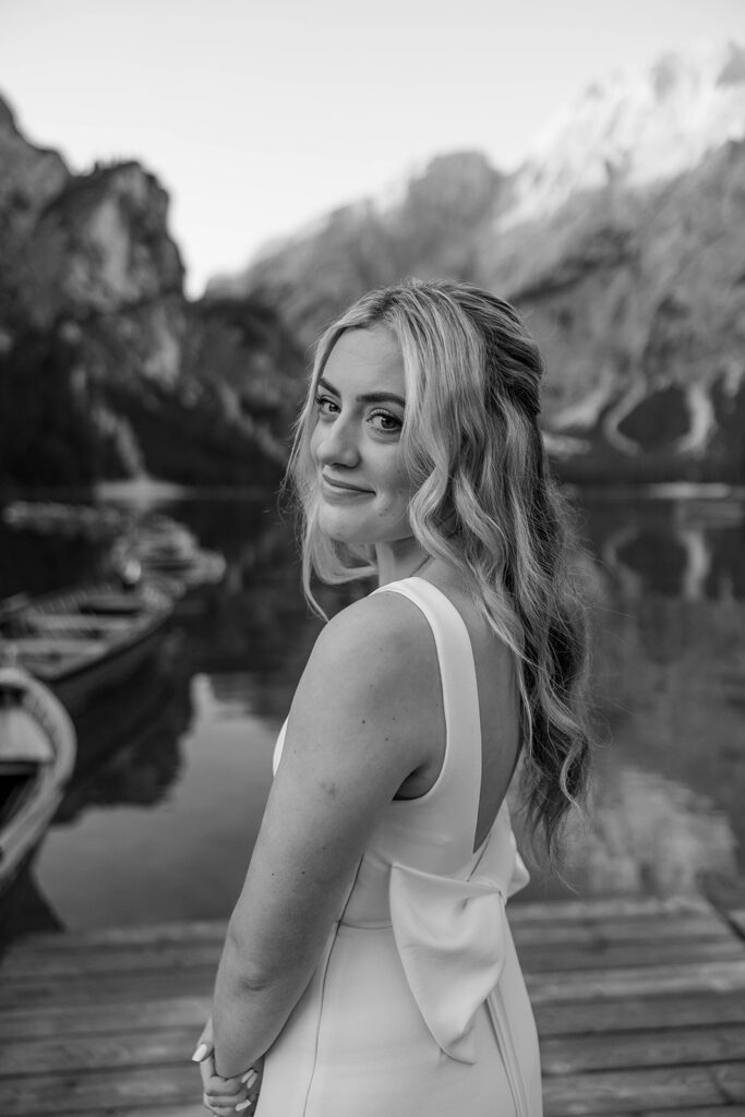 A couple capturing their special elopement moments by the serene waters of Lago di Braies in Italy’s Dolomites