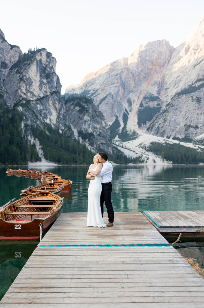 A pair enjoying their elopement photoshoot in the stunning setting of Lago di Braies, surrounded by the Dolomites in Italy.
