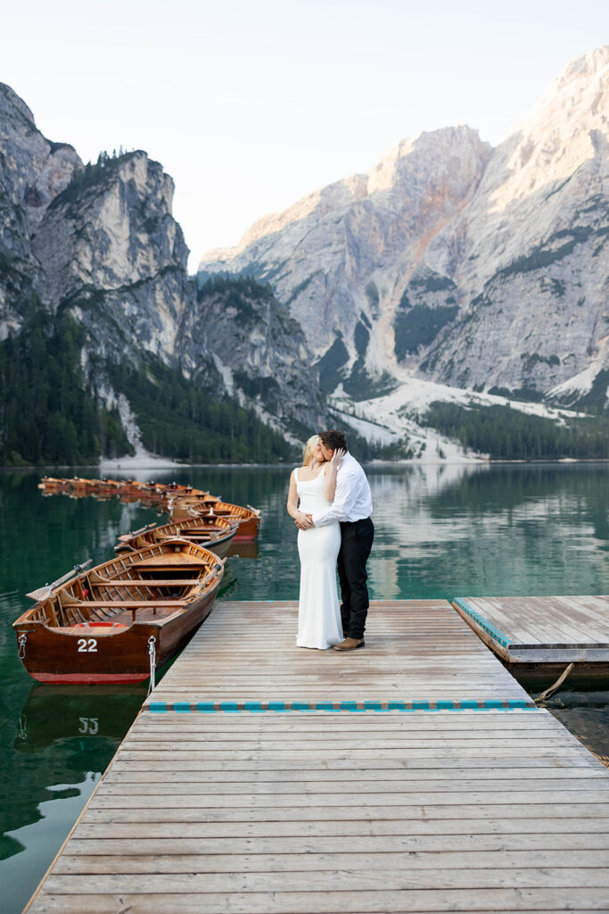 A couple capturing their special elopement moments by the serene waters of Lago di Braies in Italy’s Dolomites
