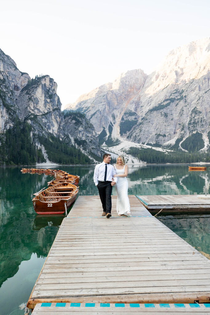 A couple capturing their special elopement moments by the serene waters of Lago di Braies in Italy’s Dolomites
