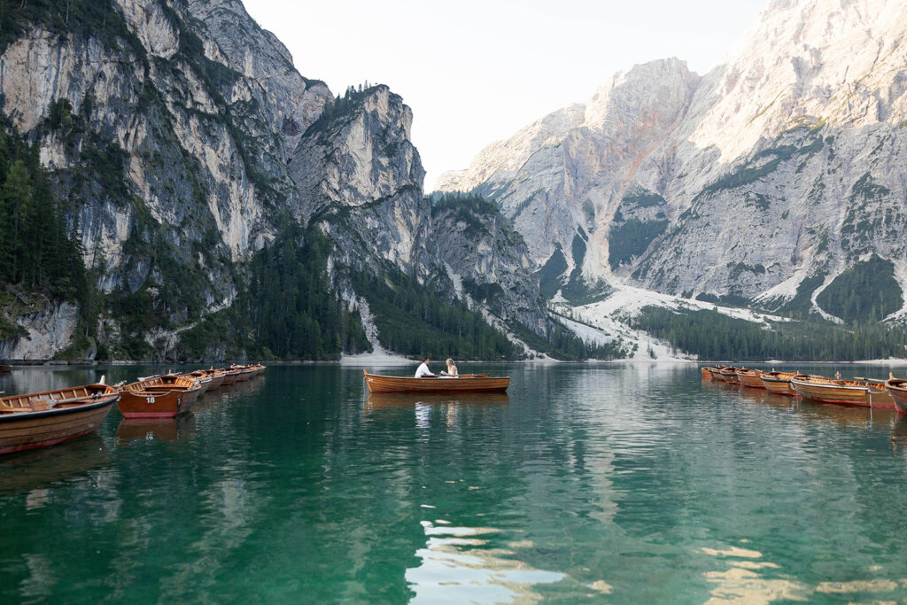 A couple standing together during their destination elopement photoshoot at Lago di Braies in the Dolomites, Italy.
