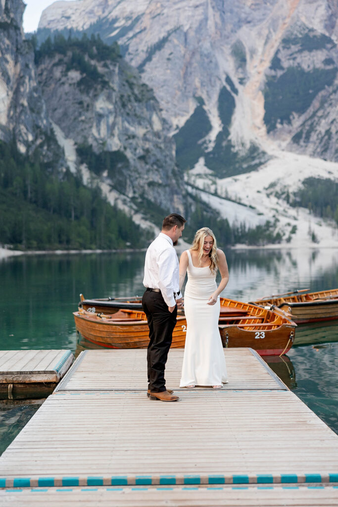 A couple capturing their special elopement moments by the serene waters of Lago di Braies in Italy’s Dolomites
