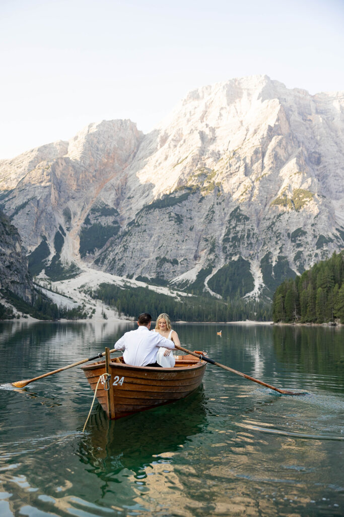 Two people posing by the picturesque Lago di Braies in the Dolomites for their destination elopement photos.
