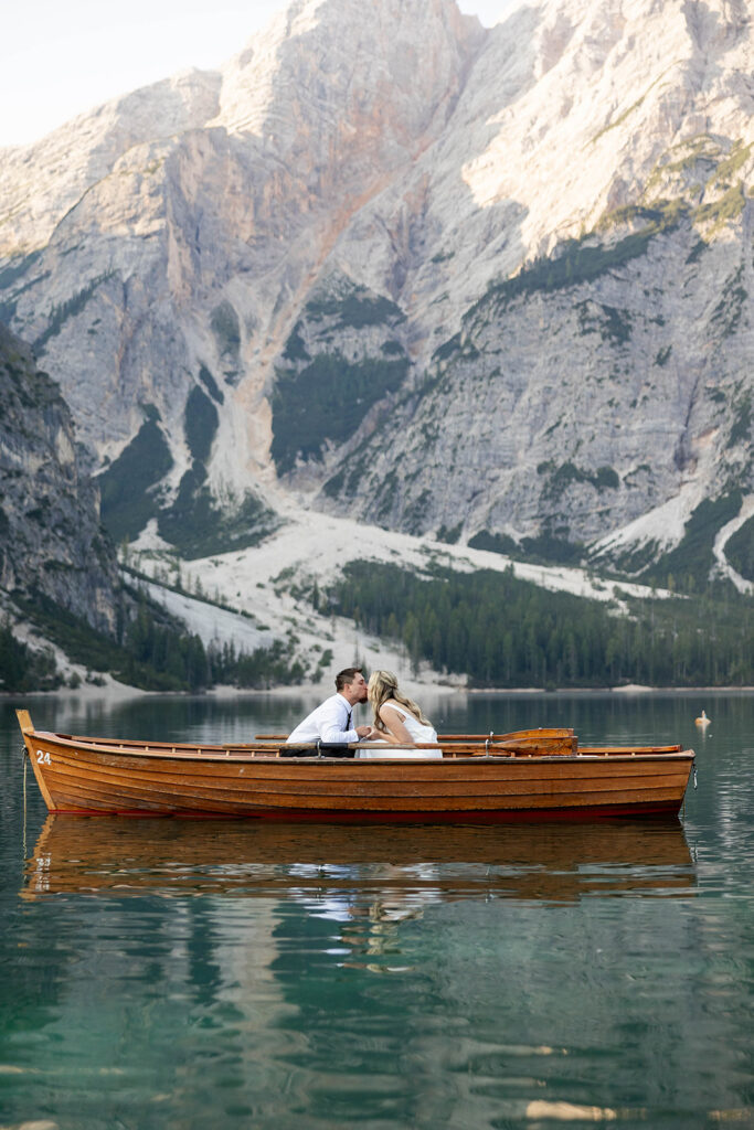 Two people posing by the picturesque Lago di Braies in the Dolomites for their destination elopement photos.