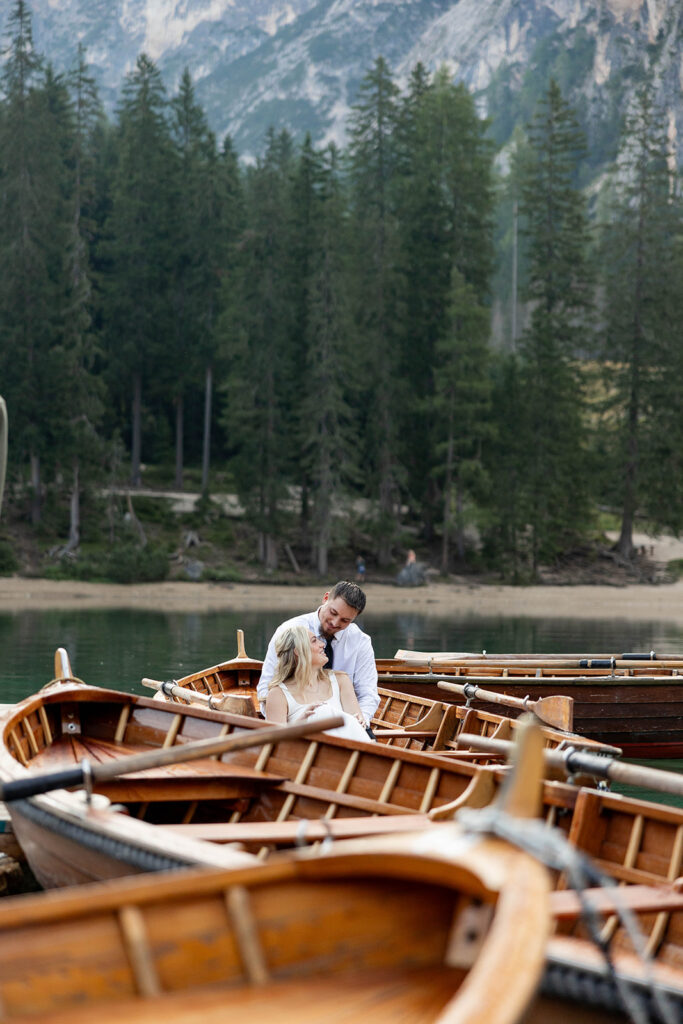 Two people posing by the picturesque Lago di Braies in the Dolomites for their destination elopement photos.