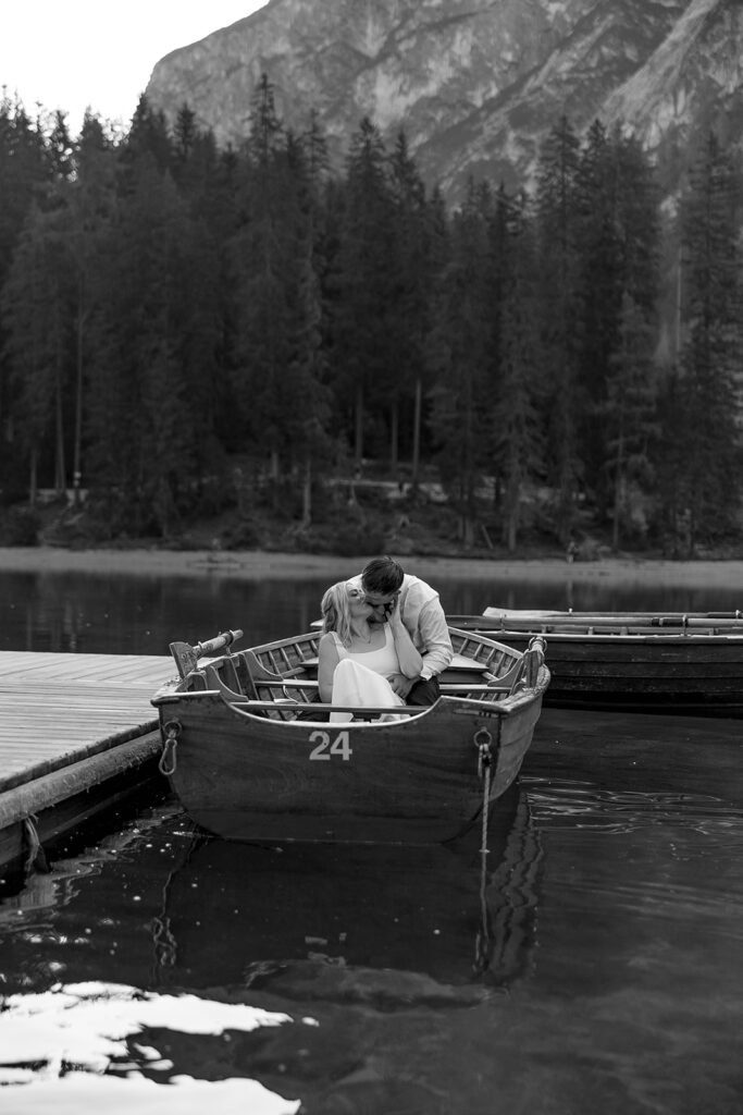 Two people posing by the picturesque Lago di Braies in the Dolomites for their destination elopement photos.
