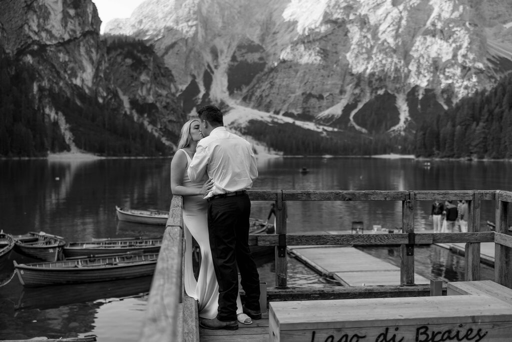 Two people posing by the picturesque Lago di Braies in the Dolomites for their destination elopement photos.
