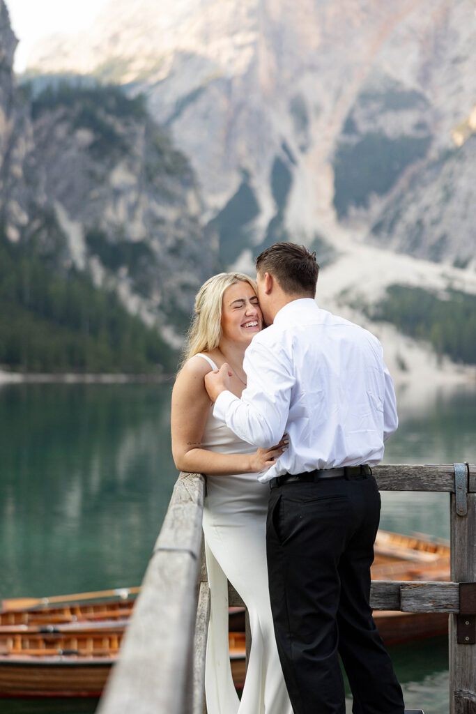 Two people posing by the picturesque Lago di Braies in the Dolomites for their destination elopement photos.
