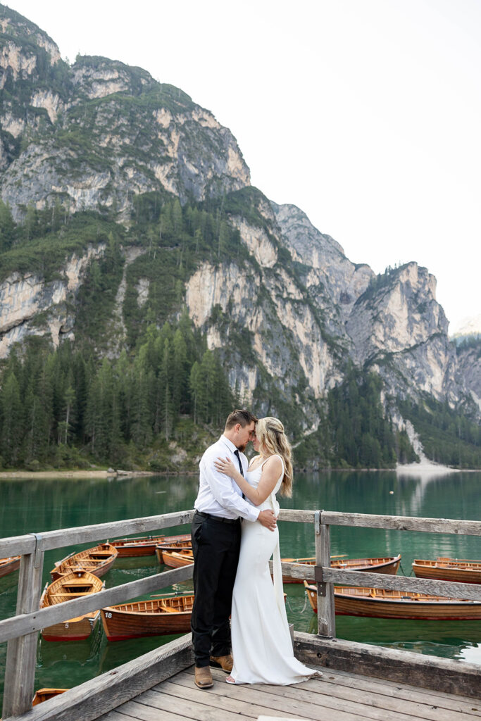 A couple standing together during their destination elopement photoshoot at Lago di Braies in the Dolomites, Italy.